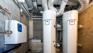 Boiler für Warm- und Kaltwasser in einem Mehrfamilienhaus (GEAK A/A) in Vollèges (VS), das ohne Zentralheizung auskommt. Das Warmwasser wird durch Solarenergie erhitzt.